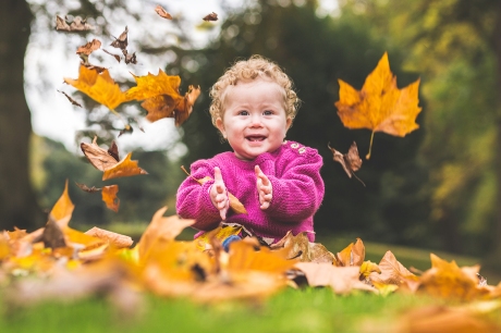 Esme claps in wonderment at the falling Autumn leaves